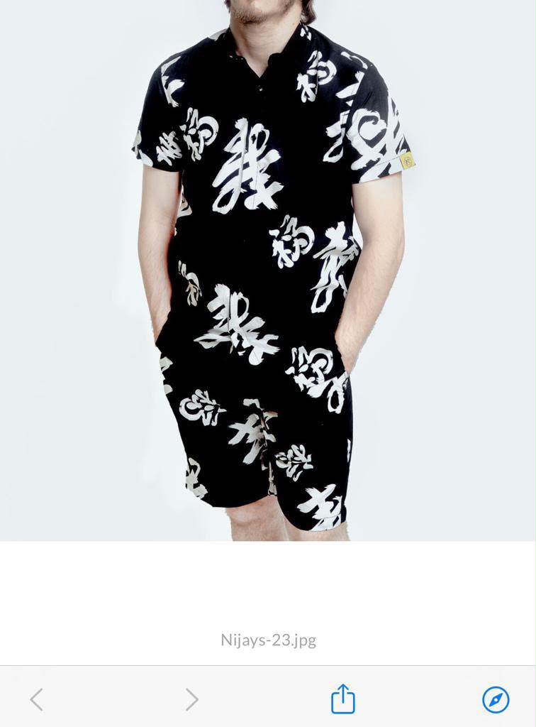 Model wearing the Nijays Couture black and white symbol print shirt and matching shorts